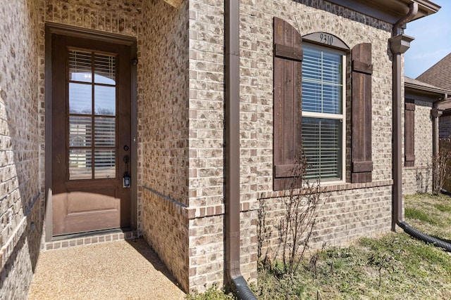 doorway to property with brick siding