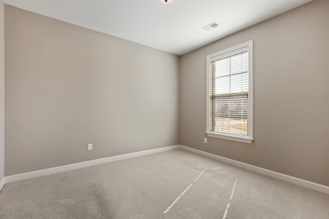 unfurnished room featuring baseboards, visible vents, and light colored carpet