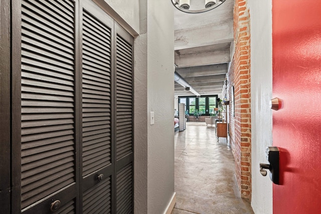 corridor featuring concrete floors, a heating unit, and a textured wall