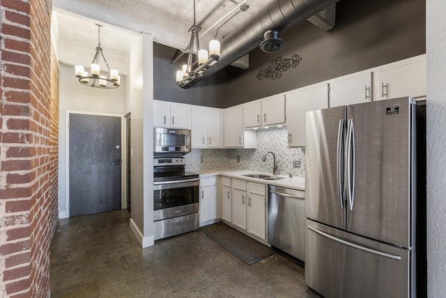 kitchen featuring a high ceiling, appliances with stainless steel finishes, a chandelier, and a sink