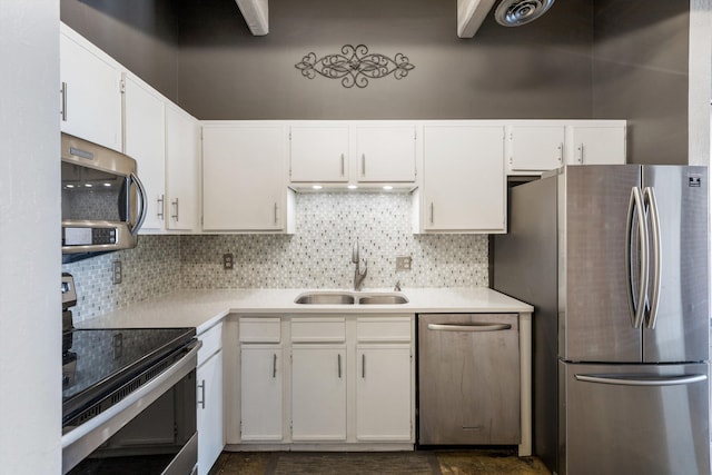 kitchen with stainless steel appliances, a sink, light countertops, and decorative backsplash