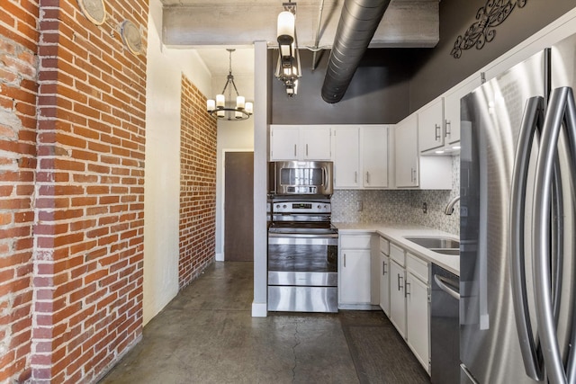 kitchen featuring a notable chandelier, a sink, a towering ceiling, light countertops, and appliances with stainless steel finishes