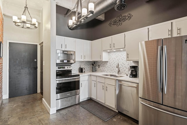 kitchen with stainless steel appliances, a sink, white cabinetry, decorative backsplash, and an inviting chandelier