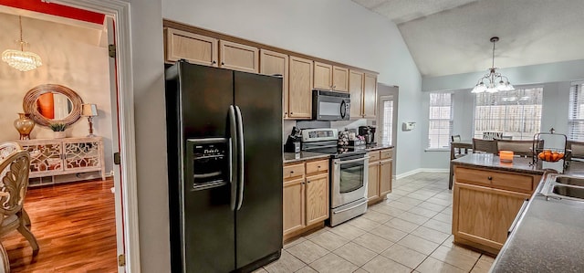 kitchen with vaulted ceiling, black appliances, dark countertops, and an inviting chandelier