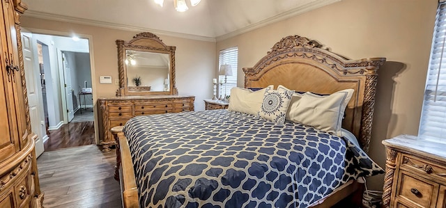 bedroom with lofted ceiling, ornamental molding, and wood finished floors