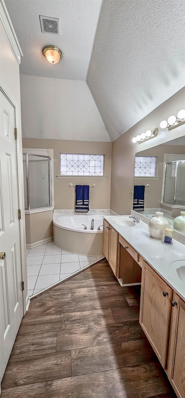 bathroom featuring wood finished floors, visible vents, an enclosed shower, and a bath