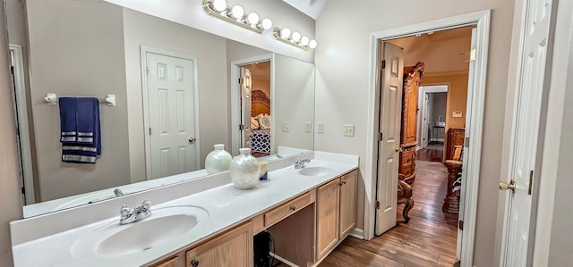 bathroom with double vanity, wood finished floors, and a sink