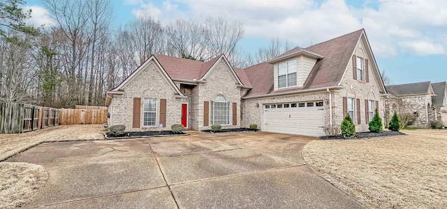 view of front of home featuring brick siding, a shingled roof, fence, a garage, and driveway