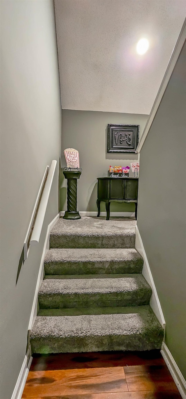 stairway with baseboards and wood finished floors