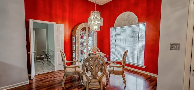 dining space with baseboards, an inviting chandelier, and wood finished floors