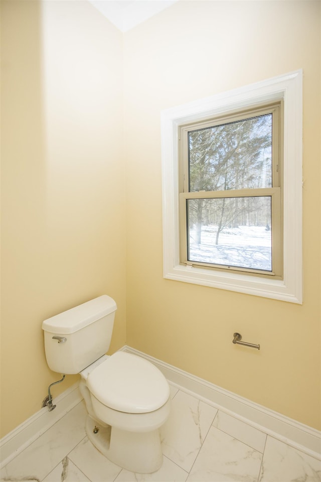 bathroom featuring marble finish floor, toilet, and baseboards