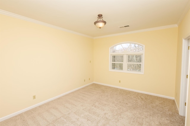 spare room with ornamental molding, light colored carpet, visible vents, and baseboards