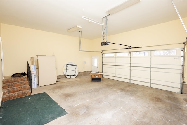 garage featuring freestanding refrigerator and a garage door opener