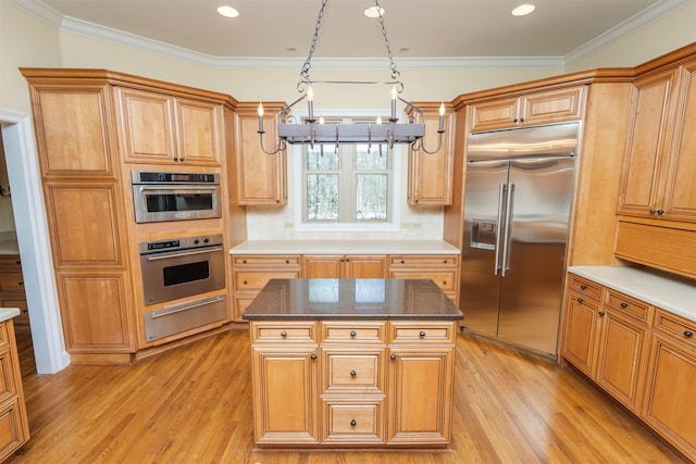 kitchen featuring appliances with stainless steel finishes, crown molding, a warming drawer, and light wood-style flooring