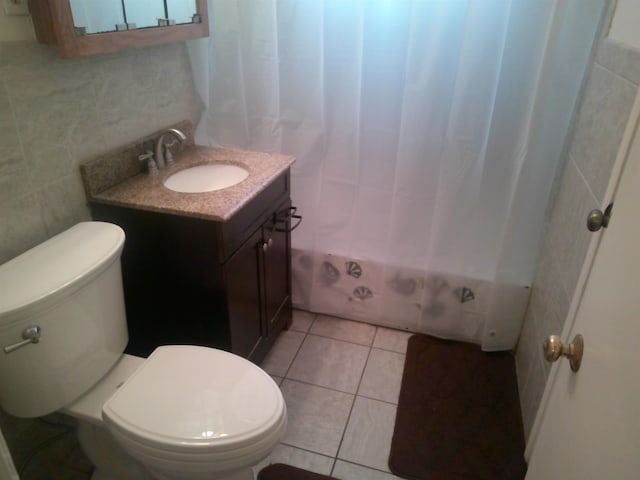 full bath with toilet, tile patterned flooring, tile walls, and vanity