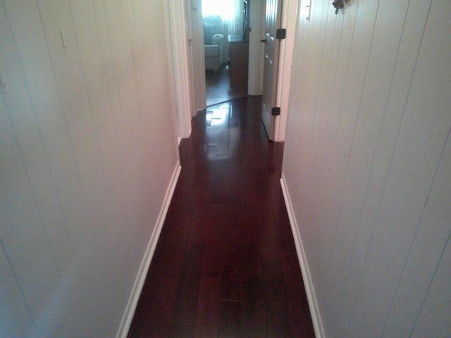 hall featuring dark wood-style floors and baseboards