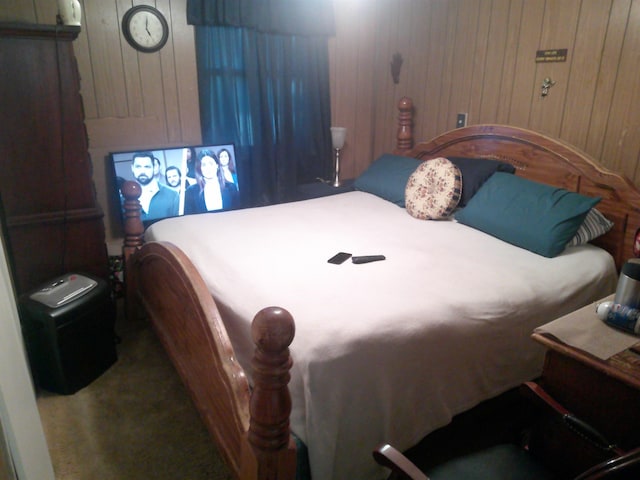 bedroom with carpet flooring and wooden walls