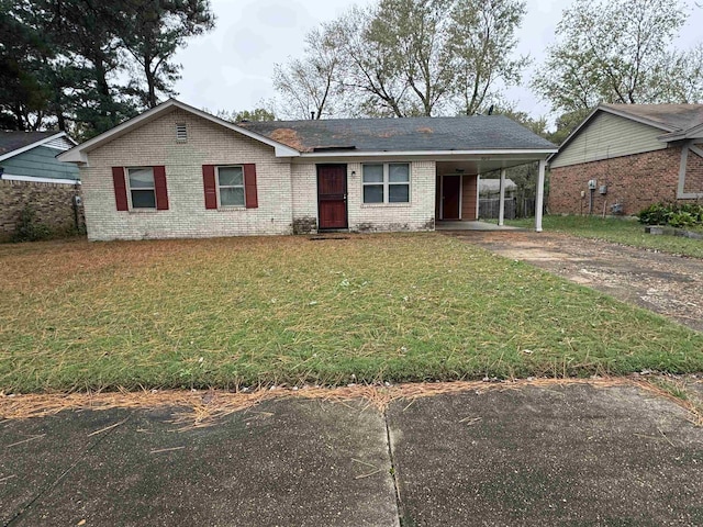 ranch-style home featuring driveway, brick siding, a carport, and a front yard