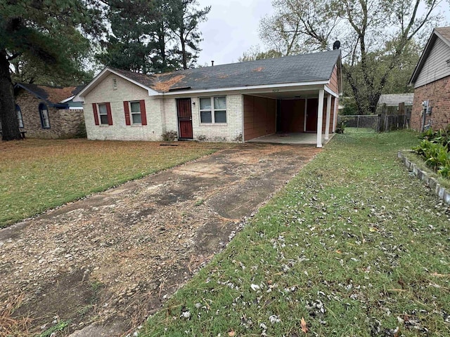 ranch-style house with an attached carport, brick siding, fence, concrete driveway, and a front lawn