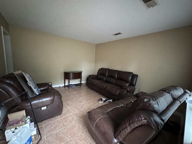 tiled living room featuring visible vents, a textured ceiling, and baseboards