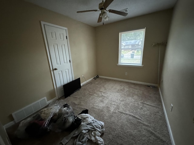 empty room with carpet floors, visible vents, and baseboards