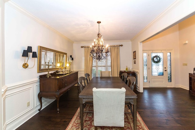 dining space with hardwood / wood-style flooring, a decorative wall, a wainscoted wall, ornamental molding, and an inviting chandelier