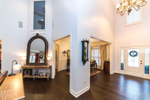 entryway featuring a healthy amount of sunlight, an inviting chandelier, baseboards, and hardwood / wood-style floors