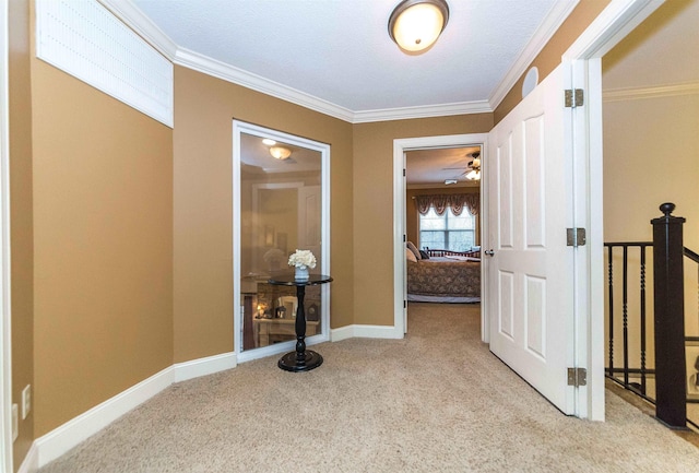 hall featuring carpet floors, ornamental molding, and baseboards