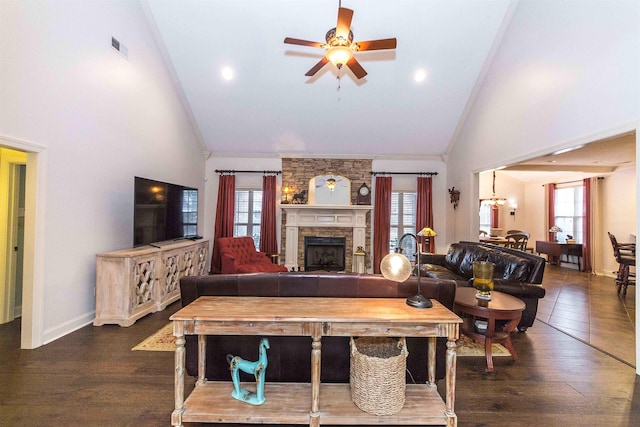 living room featuring dark wood-type flooring, a fireplace, a wealth of natural light, and crown molding