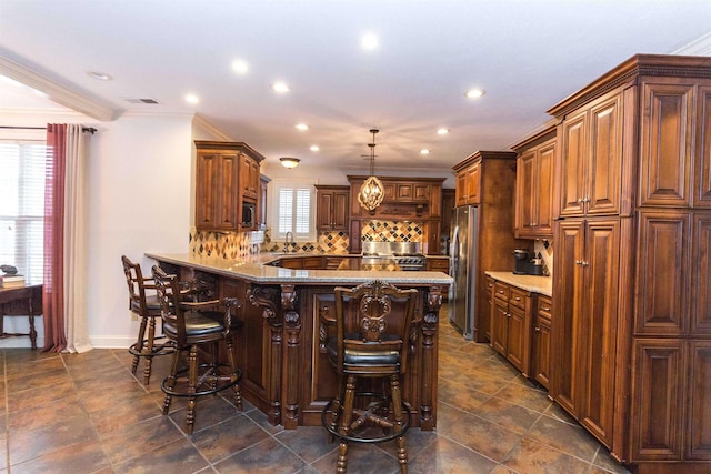 kitchen with a peninsula, a sink, appliances with stainless steel finishes, backsplash, and a kitchen bar