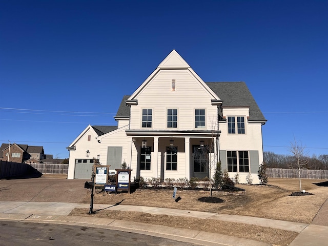 traditional-style house with a garage, a shingled roof, fence, and concrete driveway