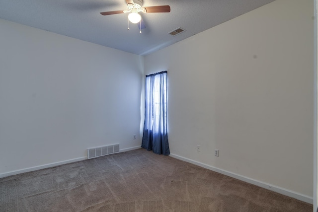 empty room with ceiling fan, carpet flooring, visible vents, and baseboards