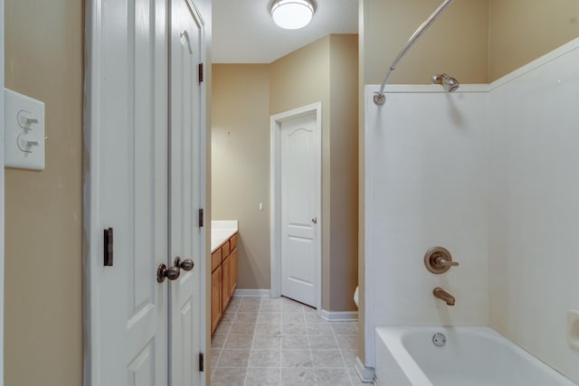 bathroom featuring tile patterned floors, bathtub / shower combination, vanity, and baseboards