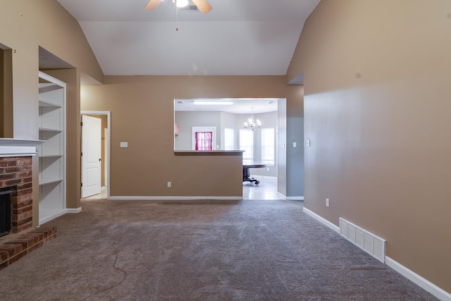 unfurnished living room featuring a brick fireplace, carpet, visible vents, and vaulted ceiling