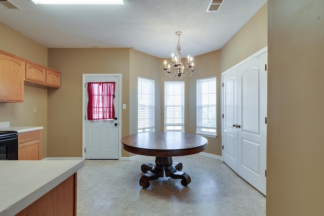 dining room with a textured ceiling, baseboards, visible vents, and an inviting chandelier