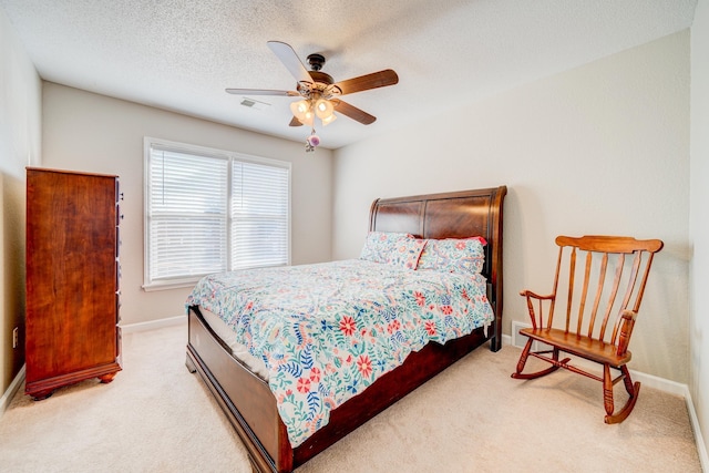 bedroom featuring a textured ceiling, baseboards, visible vents, and light colored carpet