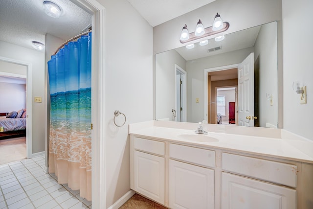 full bathroom with visible vents, a textured ceiling, ensuite bath, vanity, and baseboards