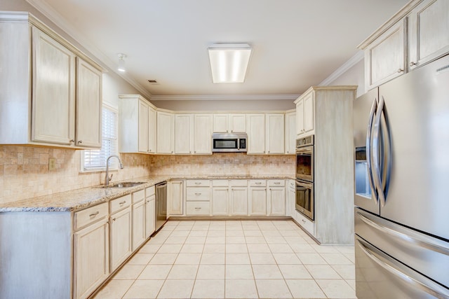 kitchen with decorative backsplash, light stone counters, appliances with stainless steel finishes, ornamental molding, and a sink