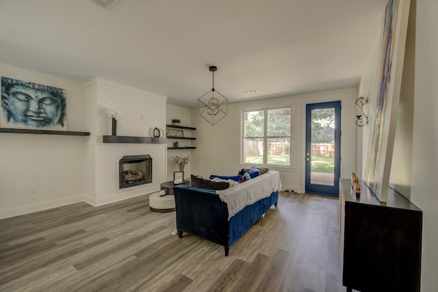 living area with a fireplace, baseboards, and wood finished floors