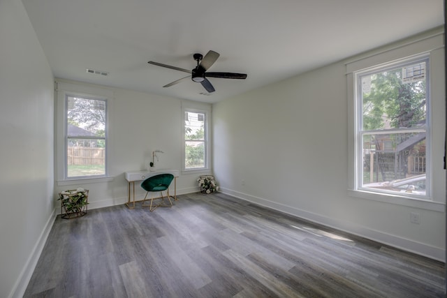 interior space featuring a ceiling fan, visible vents, baseboards, and wood finished floors