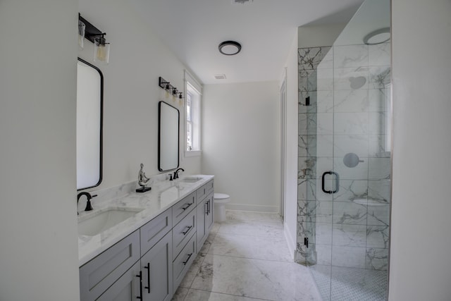 bathroom with marble finish floor, a stall shower, a sink, and toilet