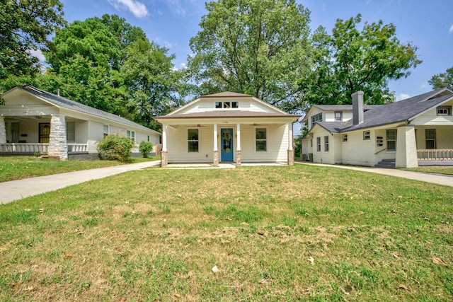 bungalow-style home with ceiling fan, a porch, and a front lawn