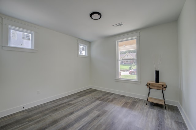 spare room with visible vents, baseboards, and wood finished floors