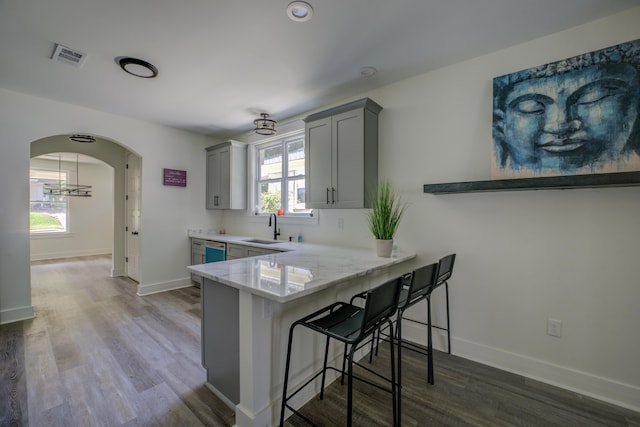 kitchen featuring a wealth of natural light, arched walkways, a sink, and gray cabinetry