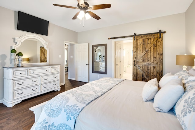 bedroom with a barn door, baseboards, ensuite bath, ceiling fan, and dark wood-type flooring