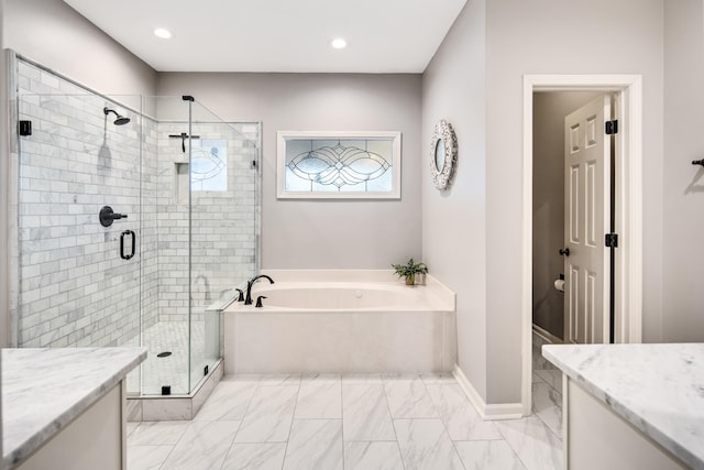 bathroom with baseboards, a garden tub, vanity, a shower stall, and recessed lighting