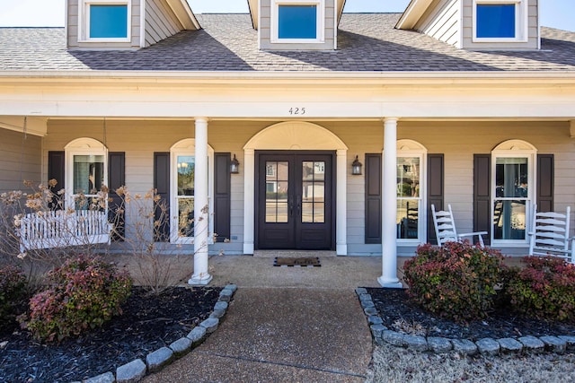 property entrance with a porch, french doors, and a shingled roof