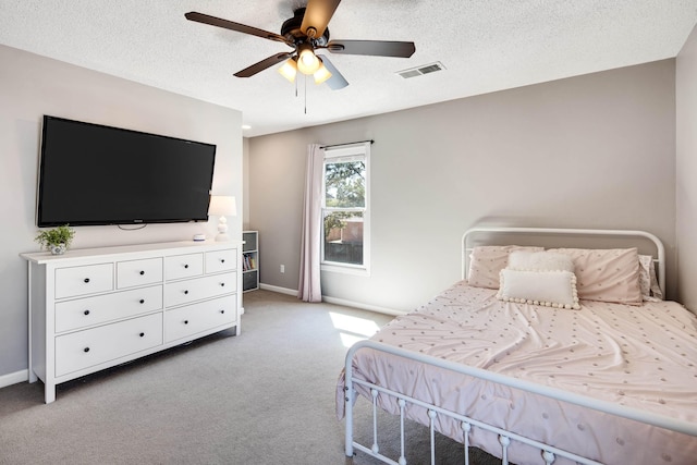 bedroom with light carpet, baseboards, visible vents, and a textured ceiling