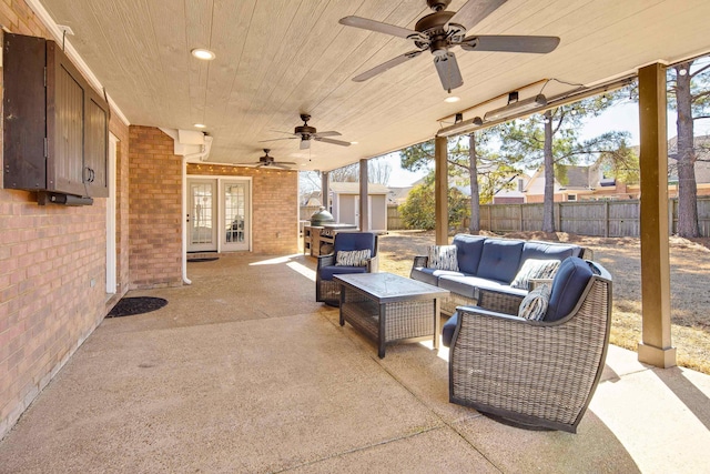 view of patio featuring french doors, a storage unit, a fenced backyard, an outdoor structure, and an outdoor living space