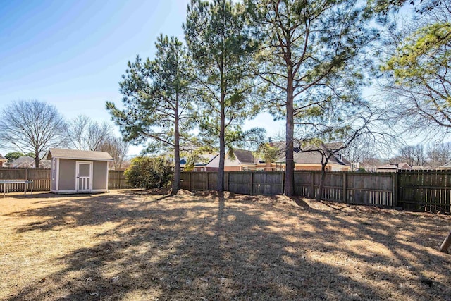 view of yard with an outbuilding, a shed, and a fenced backyard